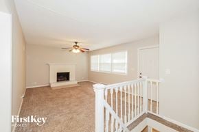 Kansas City house for rent - A living room with a fireplace and a fan on the ceiling.