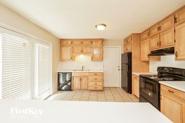Kansas City house for rent - A kitchen with wooden cabinets and black appliances.