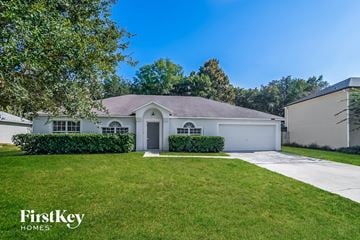 Jacksonville house for rent - a white house with a lawn and a white garage door