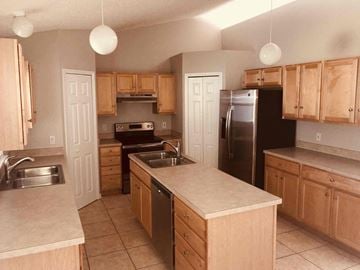 Jacksonville house for rent - a kitchen with wooden cabinets and stainless steel appliances