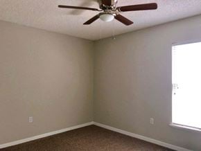 Jacksonville house for rent - a living room with a ceiling fan and a window
