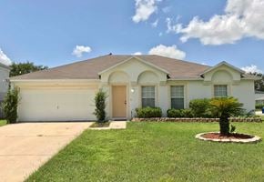 Jacksonville house for rent - the front of a white house with a lawn and a palm tree