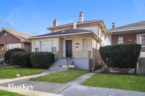 Calumet Park house for rent - a small yellow house with a sidewalk in front of it