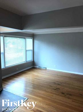Calumet Park house for rent - an empty living room with wood floors and a large window