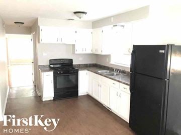 Calumet Park house for rent - an empty kitchen with black appliances and white cabinets