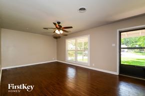 Saint Louis house for rent - an empty living room with wood floors and a ceiling fan