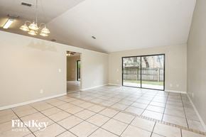 Apopka house for rent - an empty living room with a sliding glass door to a patio