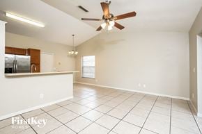 Apopka house for rent - an empty kitchen and living room with a ceiling fan