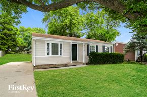 Hazelwood house for rent - A small house with a porch is surrounded by a green lawn.