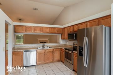 Orange Park house for rent - a kitchen with wooden cabinets and stainless steel appliances