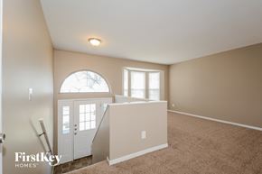 Black Jack house for rent - A room with a carpeted floor and a window with a view of trees.