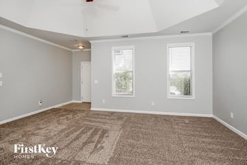 Moody house for rent - a spacious living room with carpet and two windows