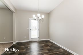 Midland house for rent - A room with a wooden floor and a chandelier hanging from the ceiling.