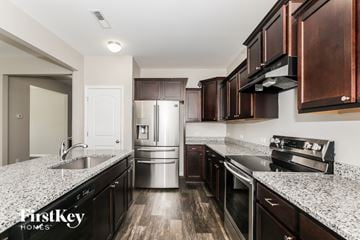 Midland house for rent - A kitchen with dark wood cabinets and stainless steel appliances.