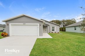 Port St. Lucie house for rent - a white house with a lawn and a driveway