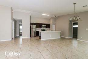 Port St. Lucie house for rent - a large kitchen with a large tiled floor and a stainless steel refrigerator