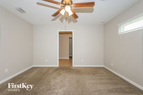 Port St. Lucie house for rent - the master bedroom has a carpeted floor and a ceiling fan