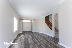 Riverview house for rent - the living room and entryway of an empty house with white walls and wood floors