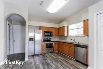 Riverview house for rent - a kitchen with stainless steel appliances and wooden cabinets