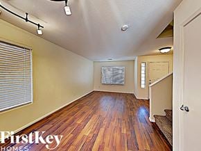 Litchfield Park house for rent - an empty living room with hardwood flooring and a door to the kitchen