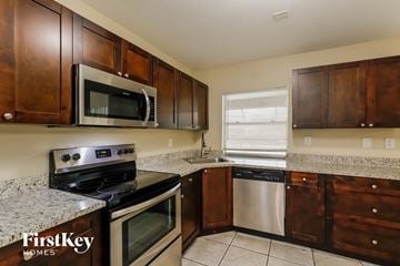 Plantation house for rent - A kitchen with wooden cabinets and a stainless steel dishwasher.