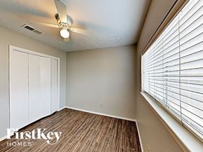 Houston house for rent - a bedroom with a large window and a ceiling fan
