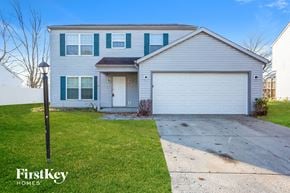 Indianapolis house for rent - a white house with a white garage door and a sidewalk