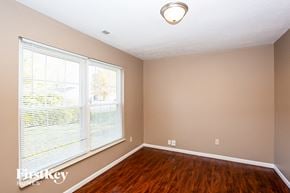 Indianapolis house for rent - a living room with a large window and wooden floors