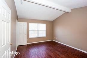 Indianapolis house for rent - a bedroom with wood floors and a white door and a window