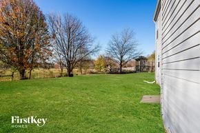 Indianapolis house for rent - a backyard with green grass and a white house