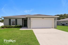 Port St. Lucie house for rent - a beige house with a garage and a lawn