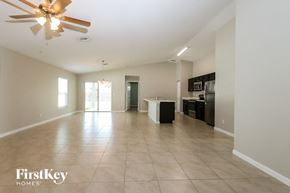 Port St. Lucie house for rent - an empty living room and kitchen with a ceiling fan