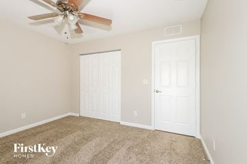Port St. Lucie house for rent - a bedroom with a ceiling fan and a closet
