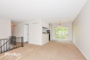 Florissant house for rent - A spacious living room with a balcony overlooking a green area.