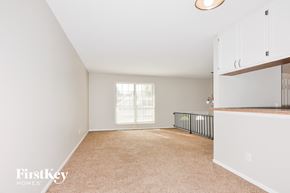 Florissant house for rent - A spacious room with white walls and a window with blinds.
