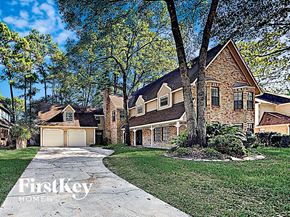 Cypress house for rent - the front of a brick house with a driveway and trees
