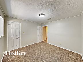 Cypress house for rent - a bedroom with a white door and a carpeted floor