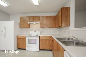 Indianapolis house for rent - a kitchen with white appliances and wooden cabinets and a sink