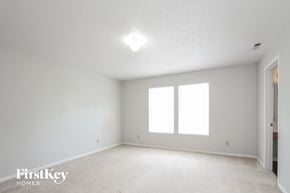 Indianapolis house for rent - a bedroom with white walls and white carpet and two windows