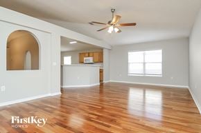 Gibsonton house for rent - an empty living room with a ceiling fan and a kitchen