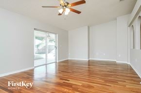 Gibsonton house for rent - a spacious living room with hardwood flooring and a ceiling fan