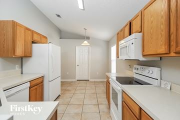 Gibsonton house for rent - a kitchen with white appliances and wooden cabinets