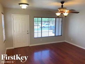 El Mirage house for rent - A room with a wooden floor and a ceiling fan.