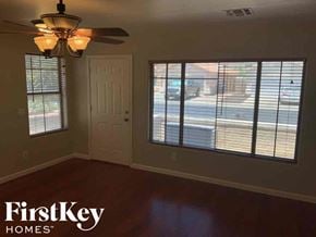 El Mirage house for rent - A room with a ceiling fan and a view of the street through the window.