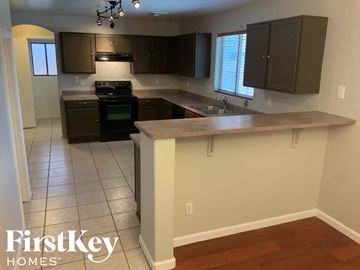 El Mirage house for rent - A kitchen with a white counter top and brown cabinets.