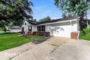 Greenwood house for rent - A house with a white garage door and a brick chimney.