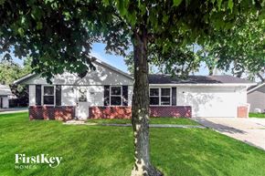 Greenwood house for rent - A tree stands in front of a house with a sign that says FirstKey Homes.