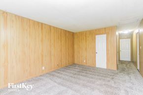 Greenwood house for rent - A room with wooden walls and carpeted floor.