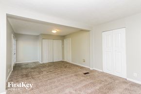 Greenwood house for rent - A spacious room with a carpeted floor and white walls.