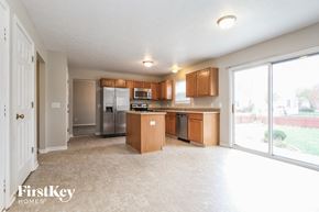 Fishers house for rent - a kitchen with wood cabinets and stainless steel appliances and a large window